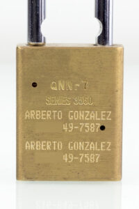 Cerradura de latón grabada con el nombre y el número de teléfono del empleado