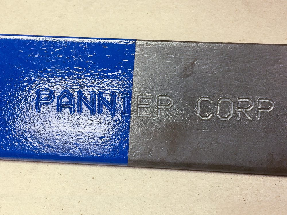 marcado profundo en una pieza de acero con pintura en la parte superior para mostrar la legibilidad
