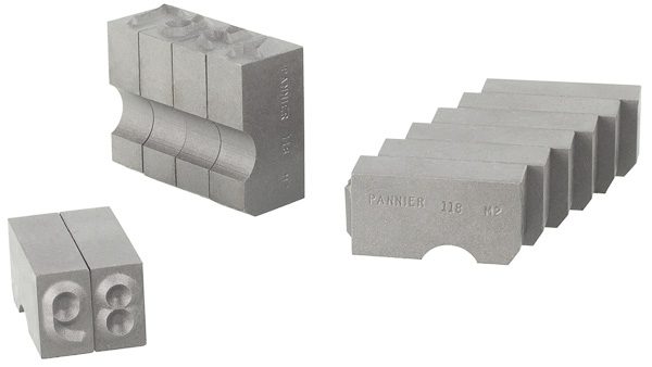 varias piezas de tipos de estampación Supreme-Safe alineadas para cargarlas en un soporte para tipos, mostrando los caracteres y las ranuras para la retención de los mismos.